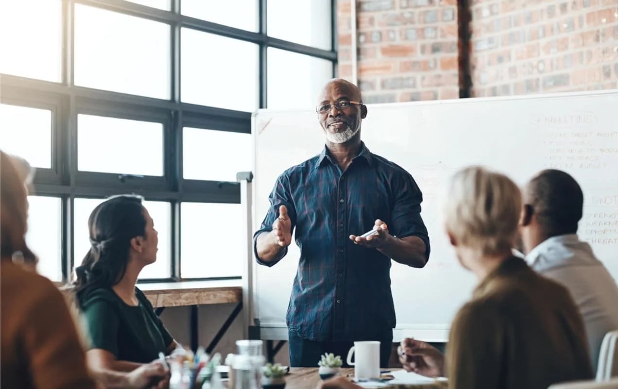 man leading a team in a meeting space