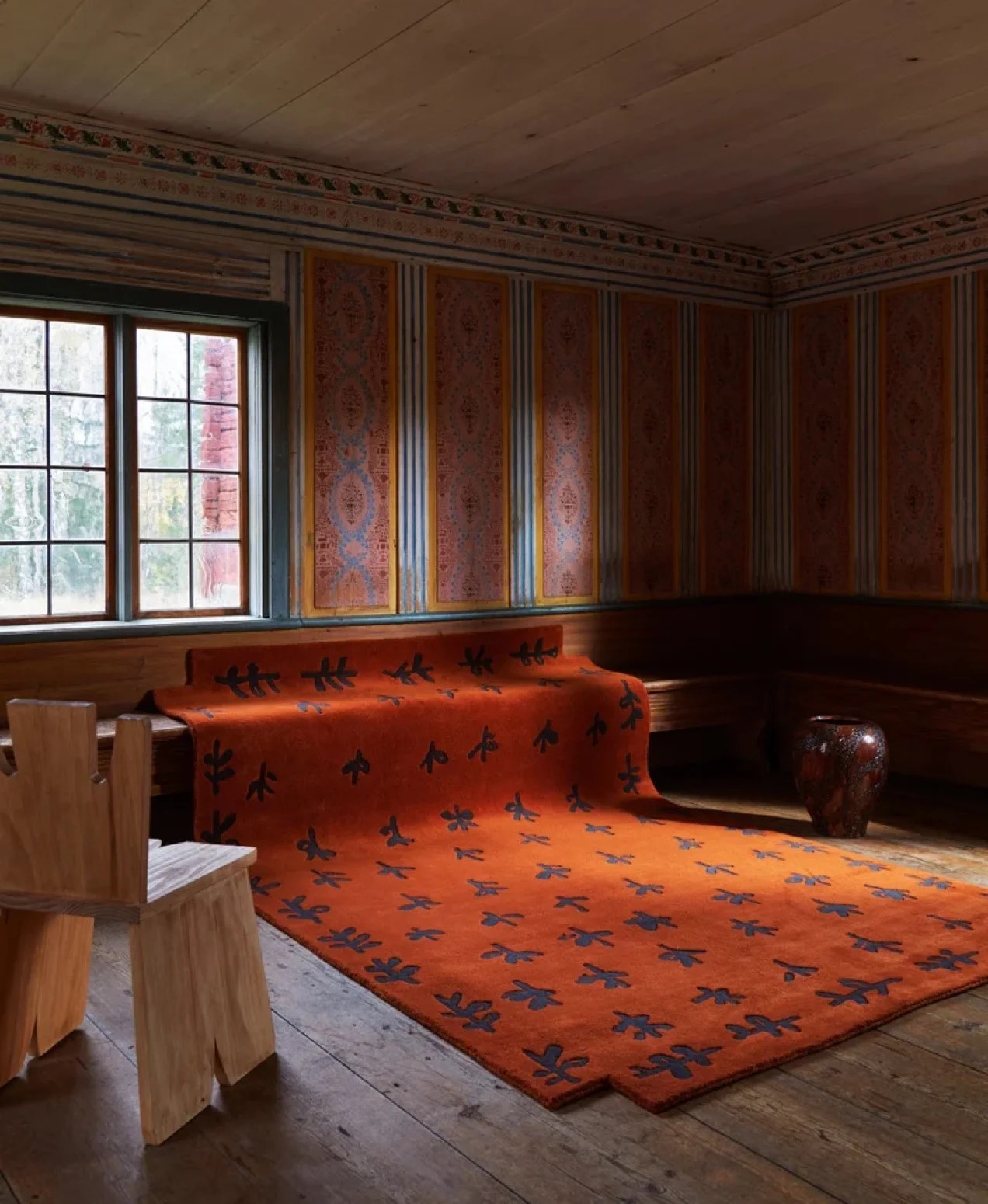 beautiful deep orange rug shown on a wooden floor