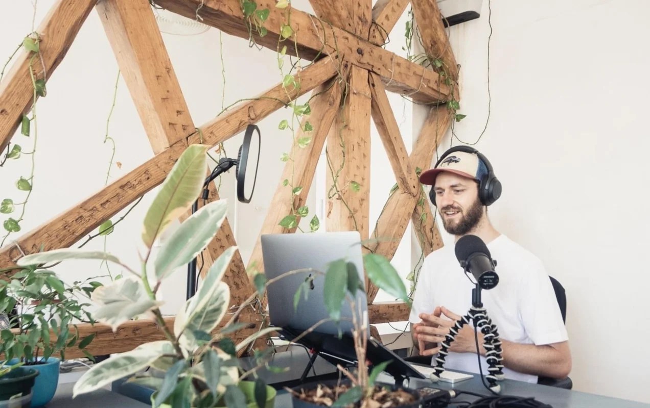 man recording a podcast in a room with plants