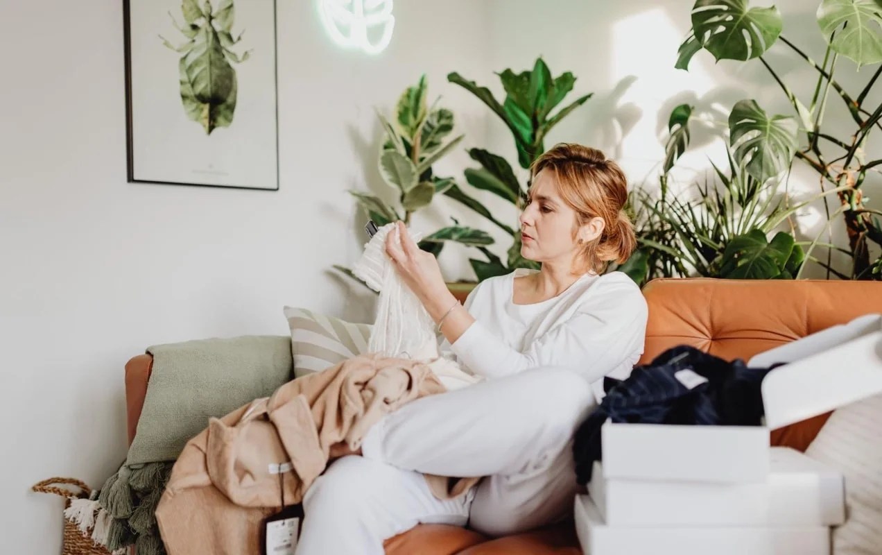 woman examining a shirt on her couch